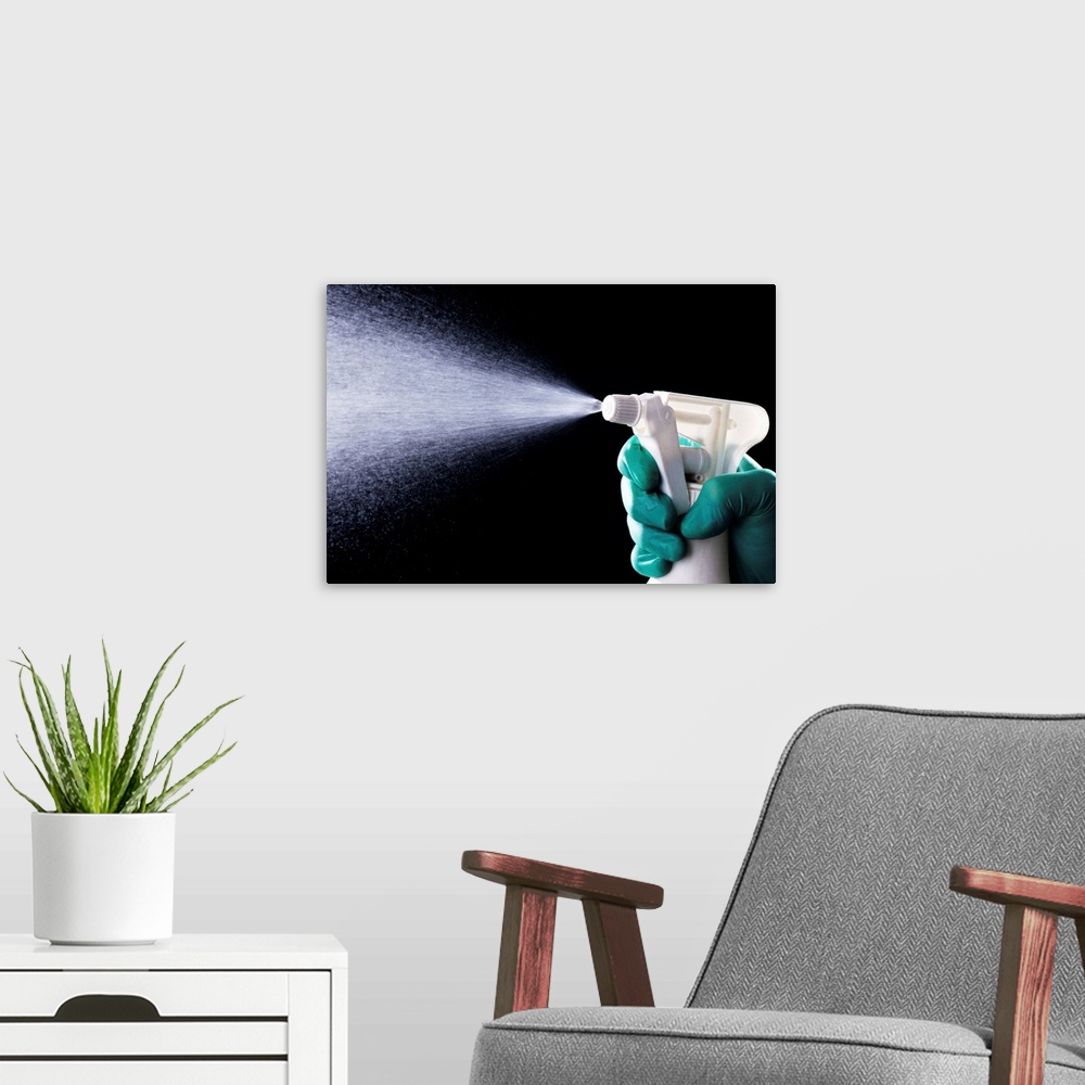 A modern room featuring Cleaning. Liquid being ejected from a plastic spray bottle.