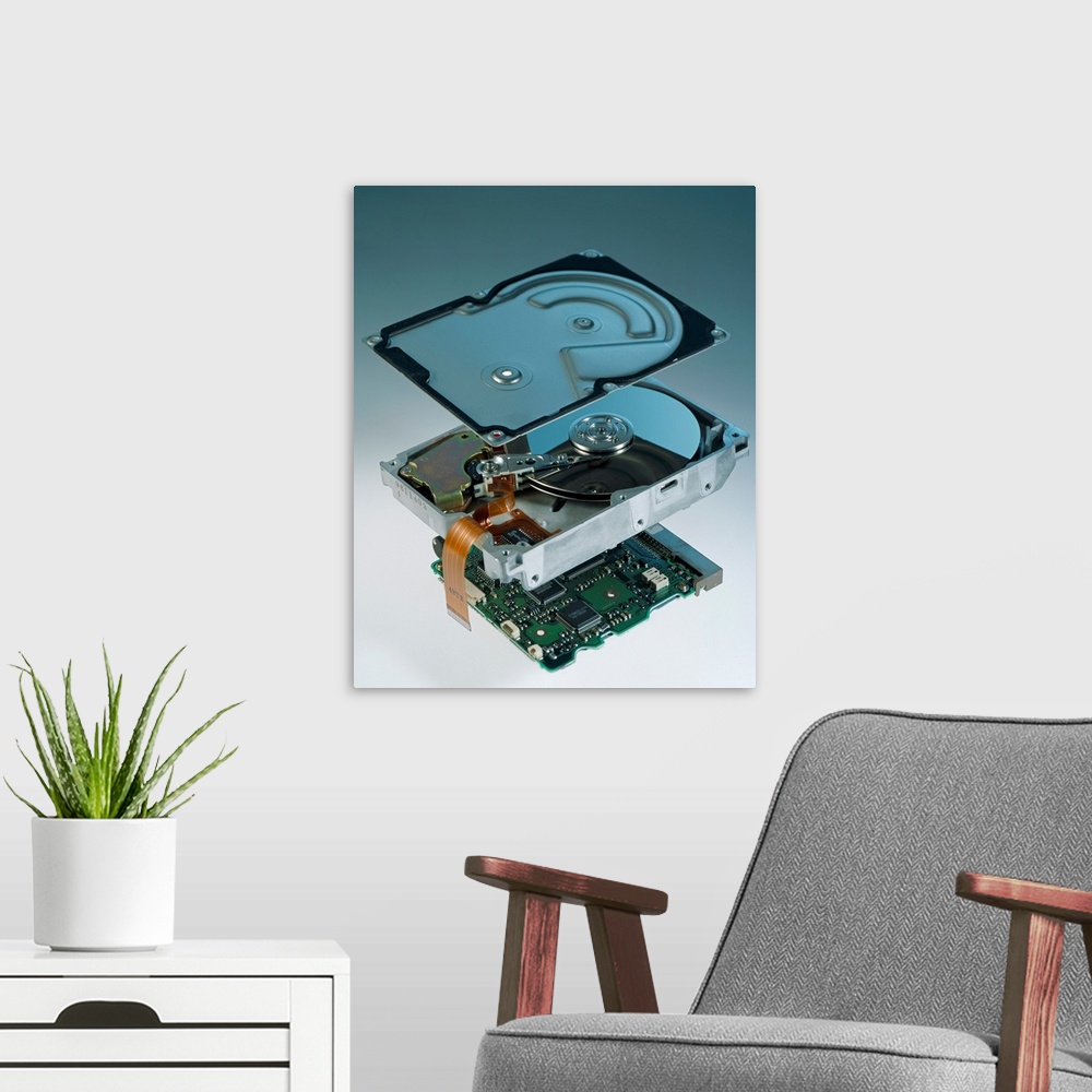 A modern room featuring Computer hard disk assembly. Component parts of a hard disk showing the outer aluminium casing (t...