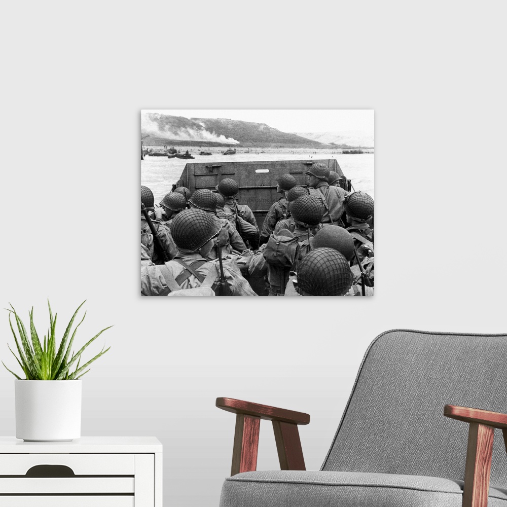 A modern room featuring D-Day landings. US assault troops in a landing craft behind its protective shield as it nears a b...