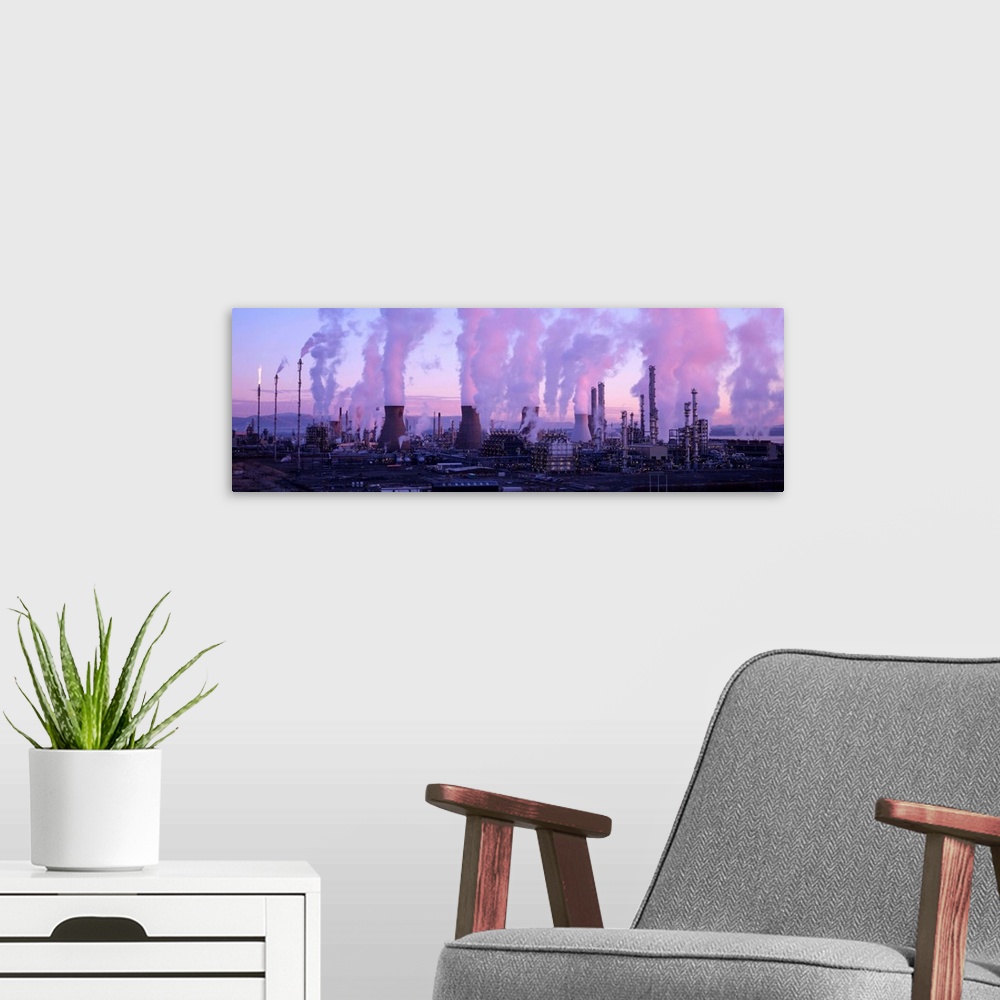A modern room featuring Petrochemical plant at dawn, with clouds of smoke and steam rising from its smokestacks and cooli...