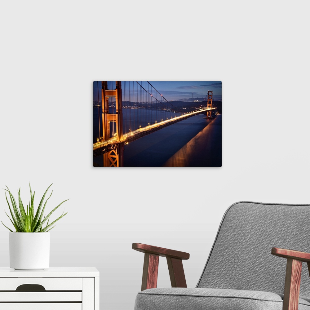 A modern room featuring Aerial photograph of the famous Golden Gate Bridge in the evening, glowing with light trails from...