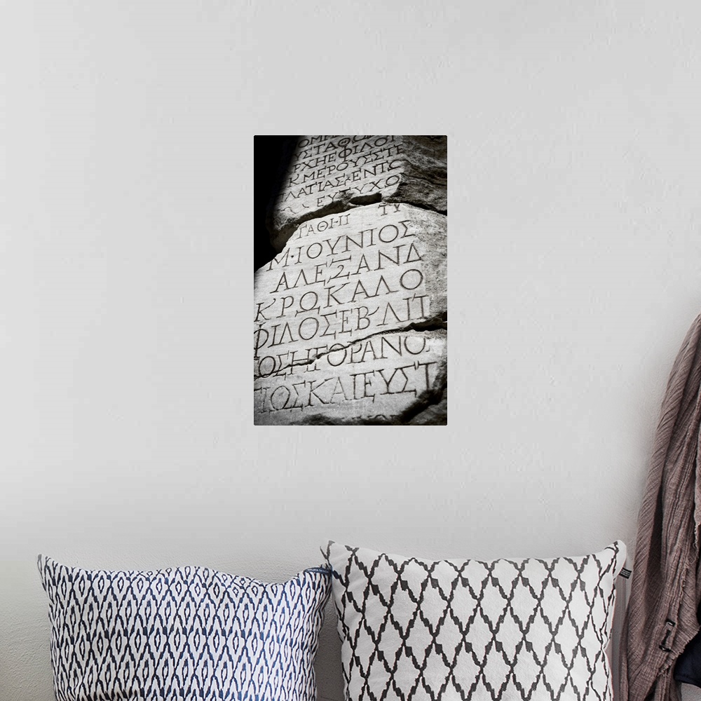 A bohemian room featuring Black and white photograph taken of ancient text carved into a stone wall.