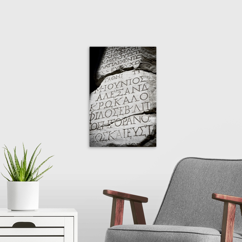 A modern room featuring Black and white photograph taken of ancient text carved into a stone wall.