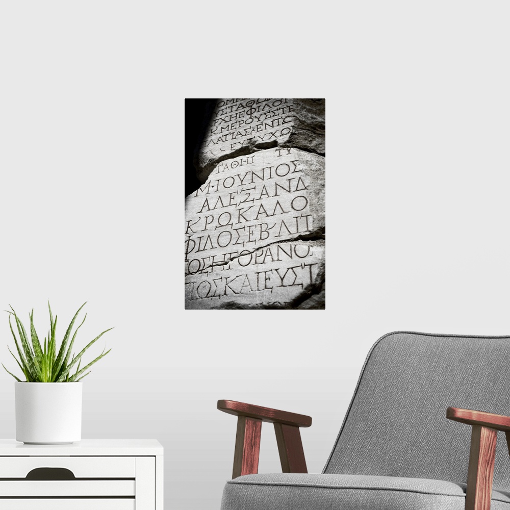 A modern room featuring Black and white photograph taken of ancient text carved into a stone wall.