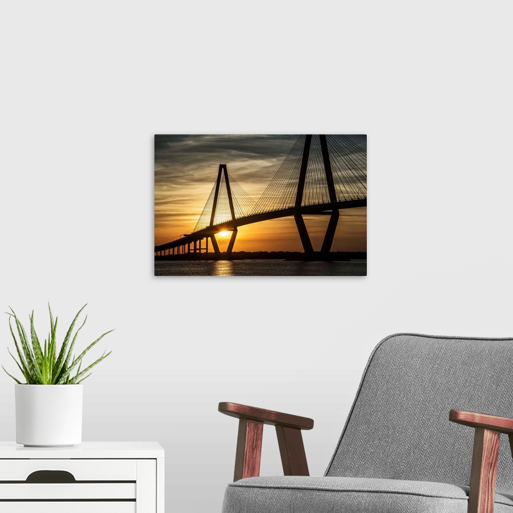 A modern room featuring Arthur Ravenel Jr. Bridge crossing the Cooper River at sunset.