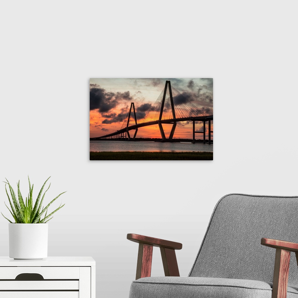 A modern room featuring Arthur Ravenel Jr. Bridge crossing the Cooper River at sunset.