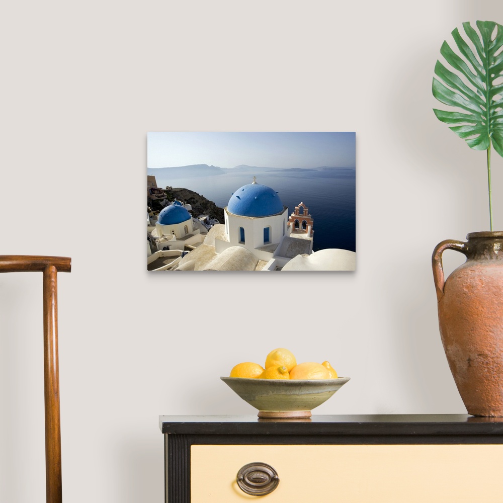 A traditional room featuring Photograph taken on the coast of Greece looking out toward the water with blue domed churches sit...