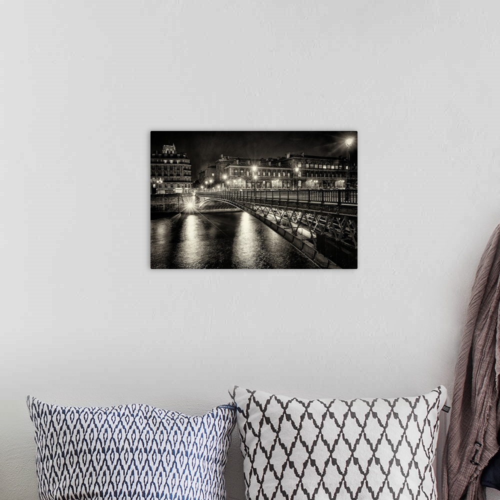 A bohemian room featuring High contrast photograph of a bridge crossing over the Seine River in Paris with lit up buildings...