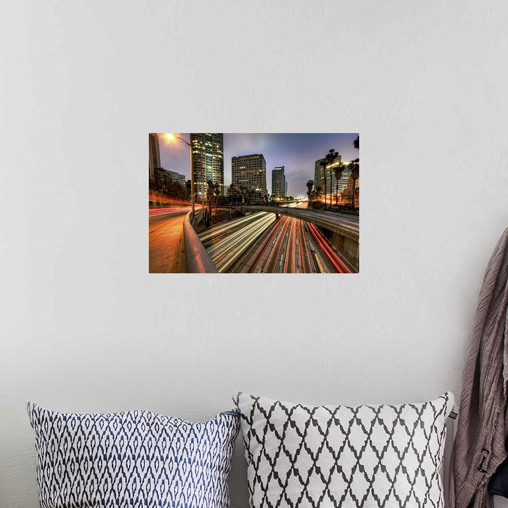 A bohemian room featuring A large photograph of some of downtown Los Angeles with the lights of cars streaking through.