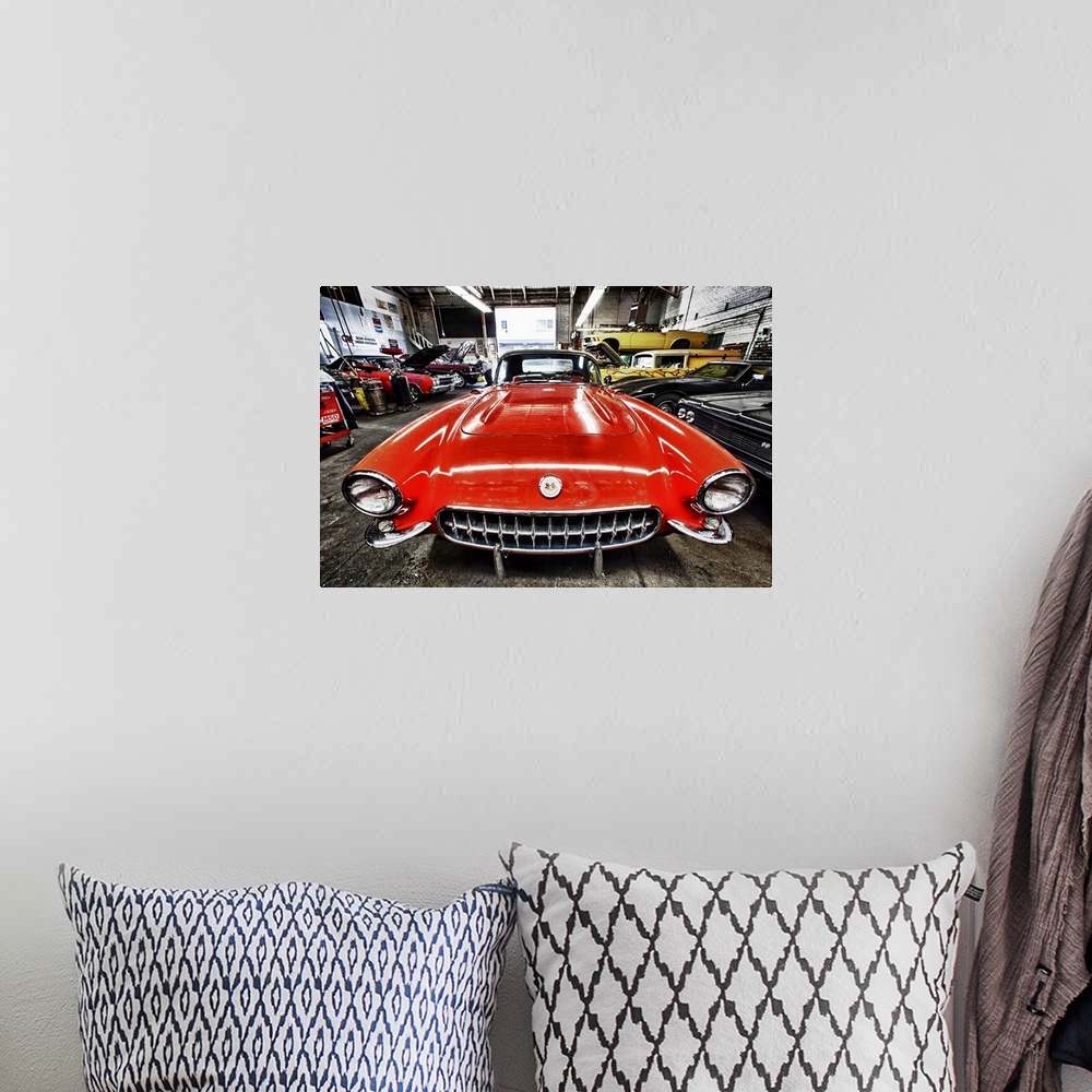 A bohemian room featuring Classic red corvette in a car repair shop