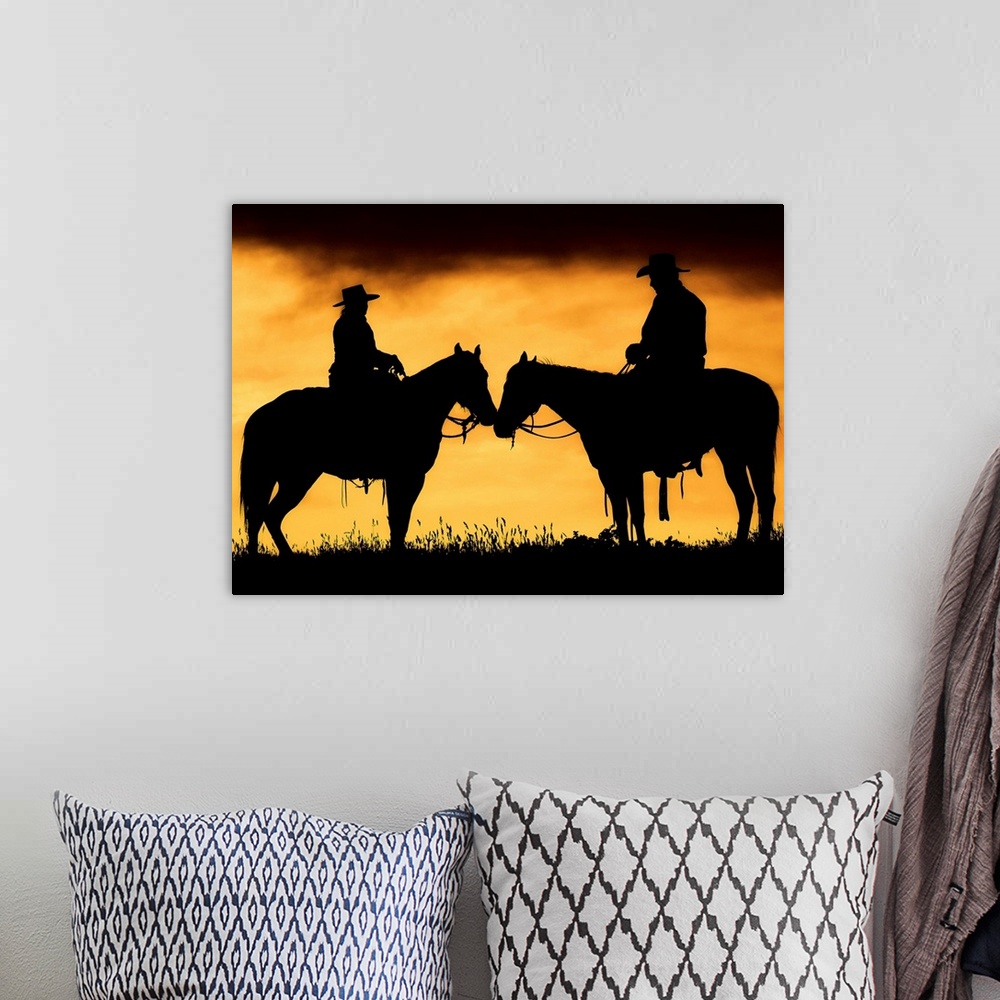A bohemian room featuring Giant photograph showcases the shadowed profiles of a man and woman sitting on a couple horses wi...