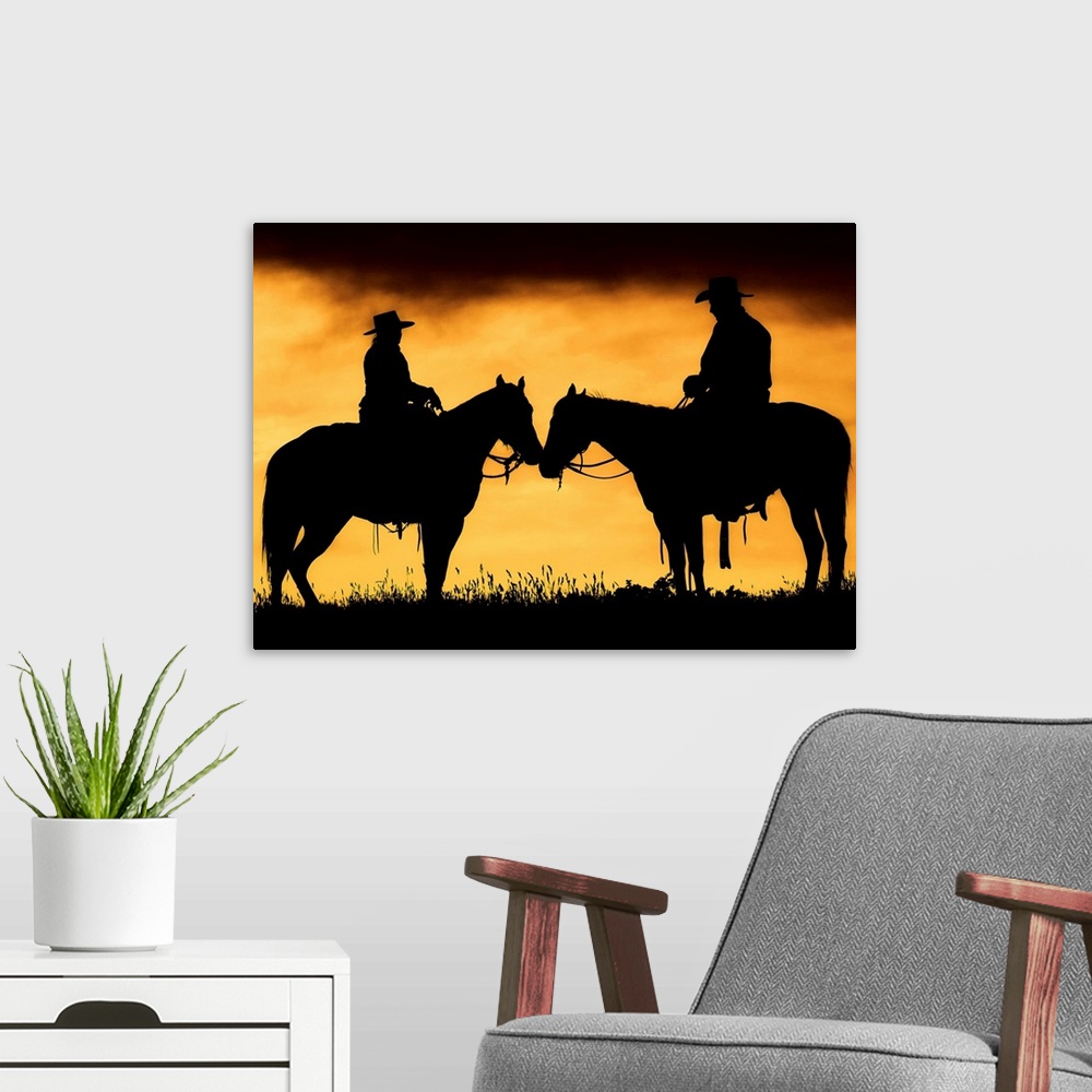 A modern room featuring Giant photograph showcases the shadowed profiles of a man and woman sitting on a couple horses wi...