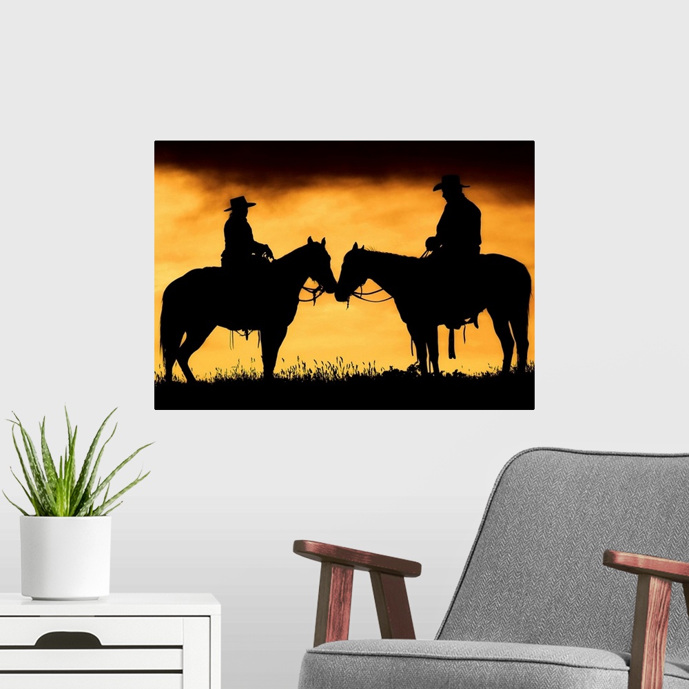 A modern room featuring Giant photograph showcases the shadowed profiles of a man and woman sitting on a couple horses wi...