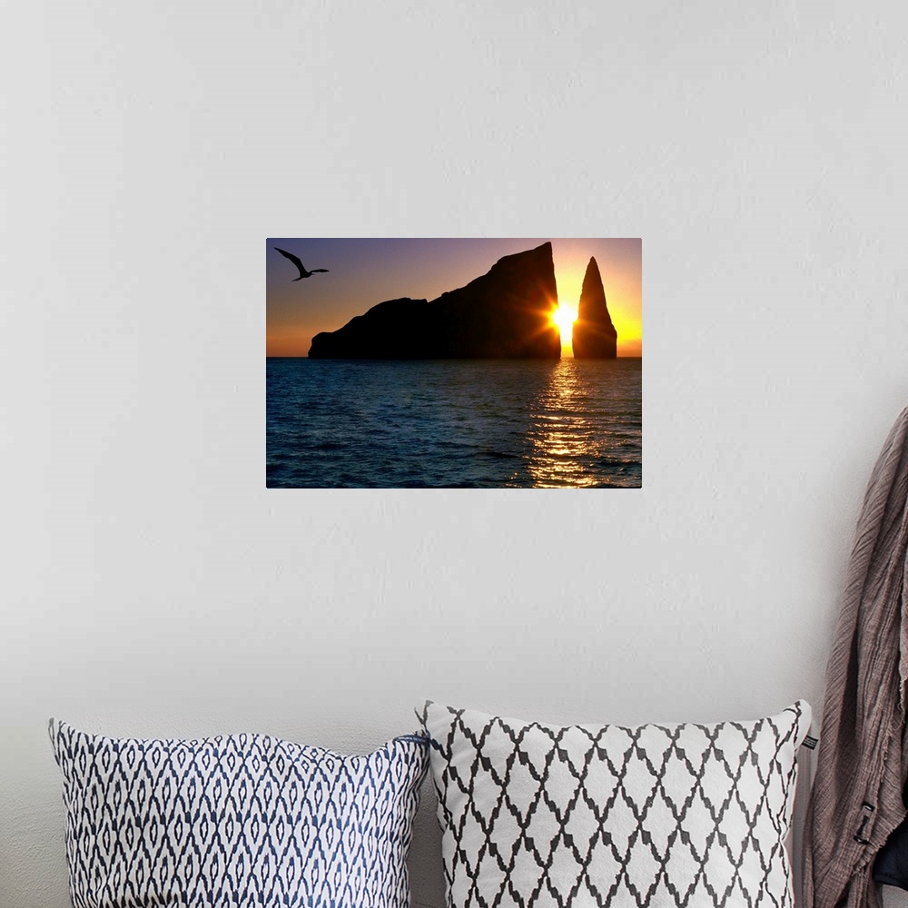 A bohemian room featuring Photograph of the sun setting between two large cliffs over the ocean in the Galapagos.