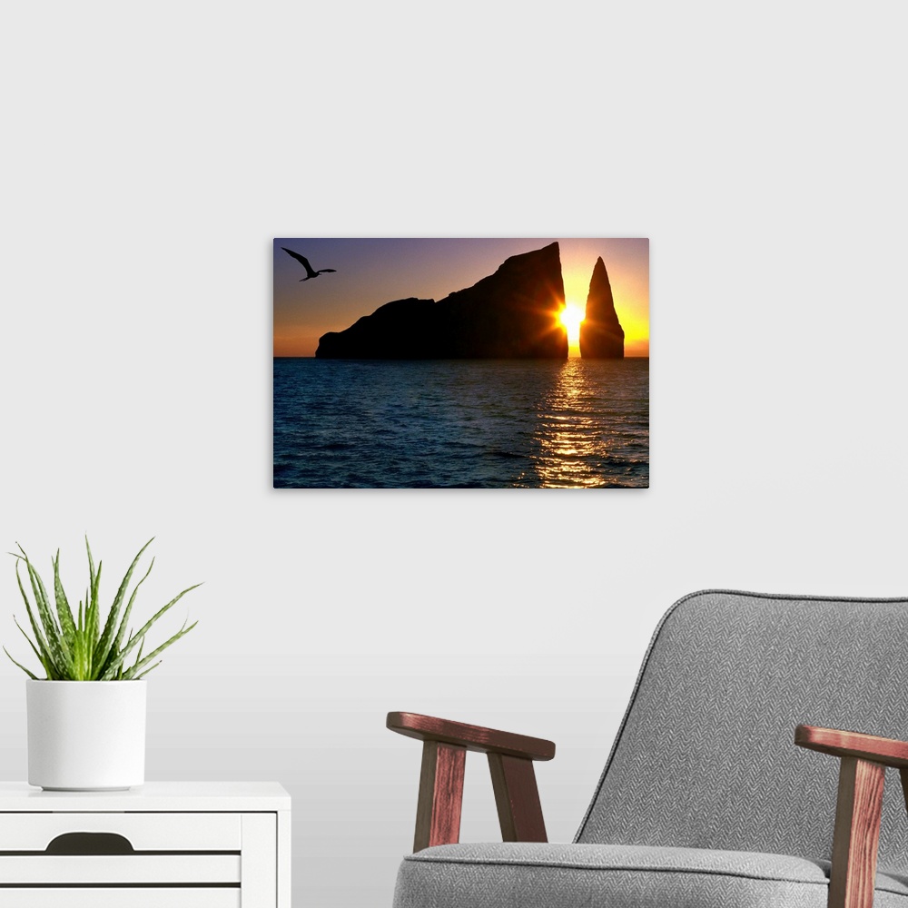 A modern room featuring Photograph of the sun setting between two large cliffs over the ocean in the Galapagos.