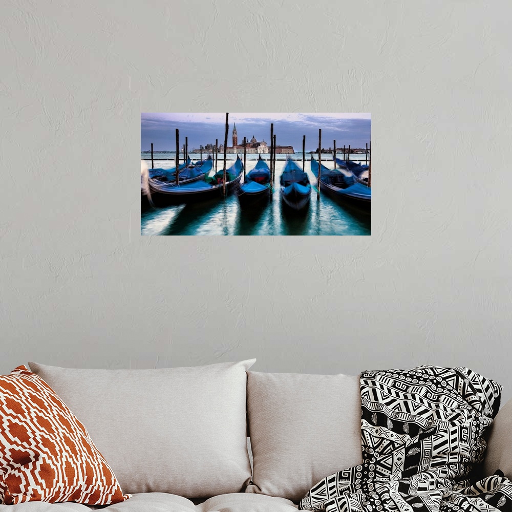A bohemian room featuring Big photograph of empty gondolas tied to poles in Venice, Italy with buildings in the background.