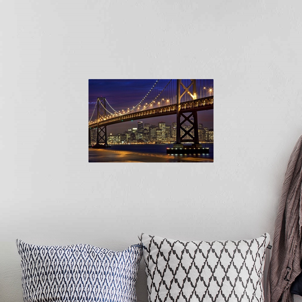 A bohemian room featuring The Bay Bridge is shining brightly under a night sky with the San Francisco skyline shown in the ...