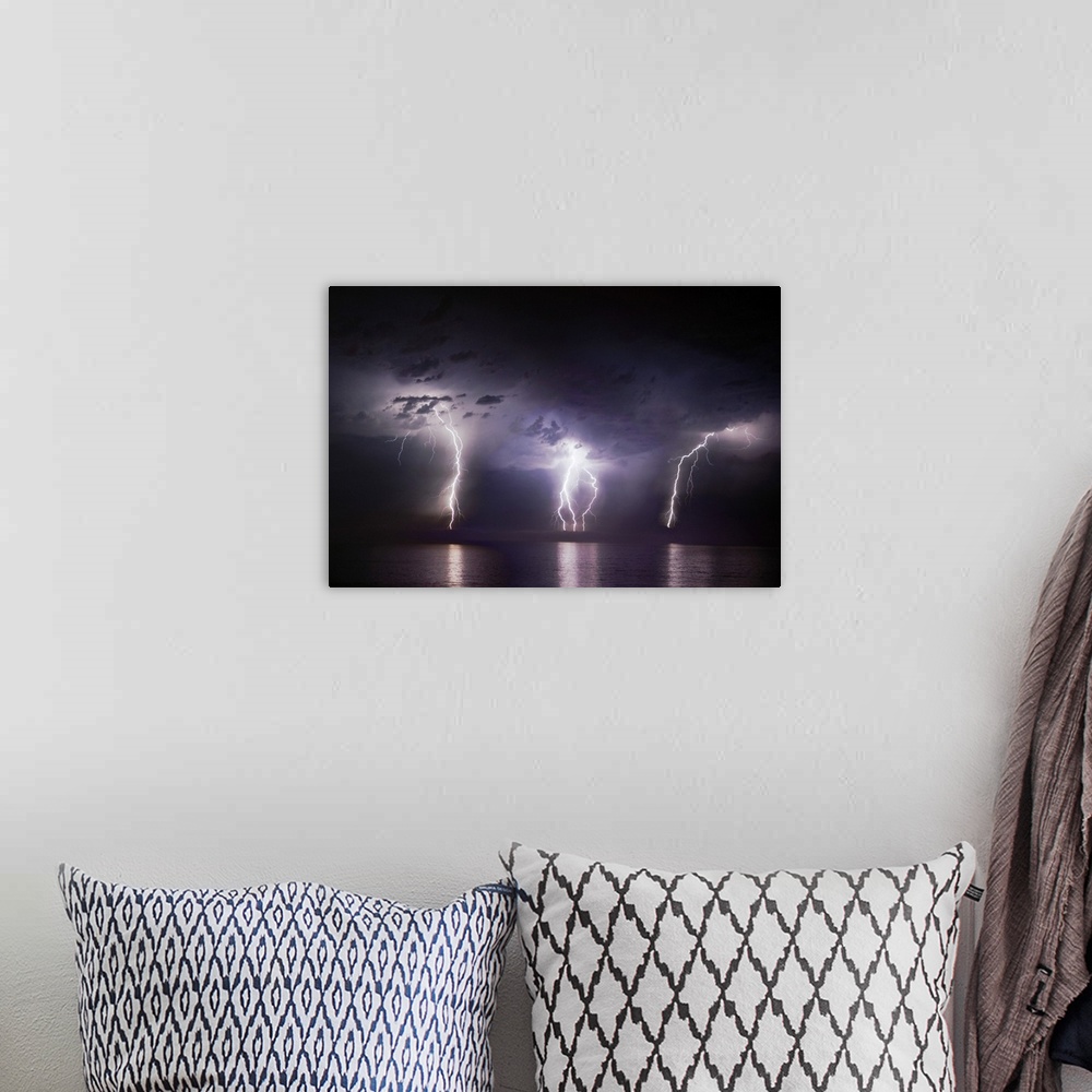 A bohemian room featuring Time-lapse photo of three bolts of lightning striking the ocean from storm clouds at night, illum...