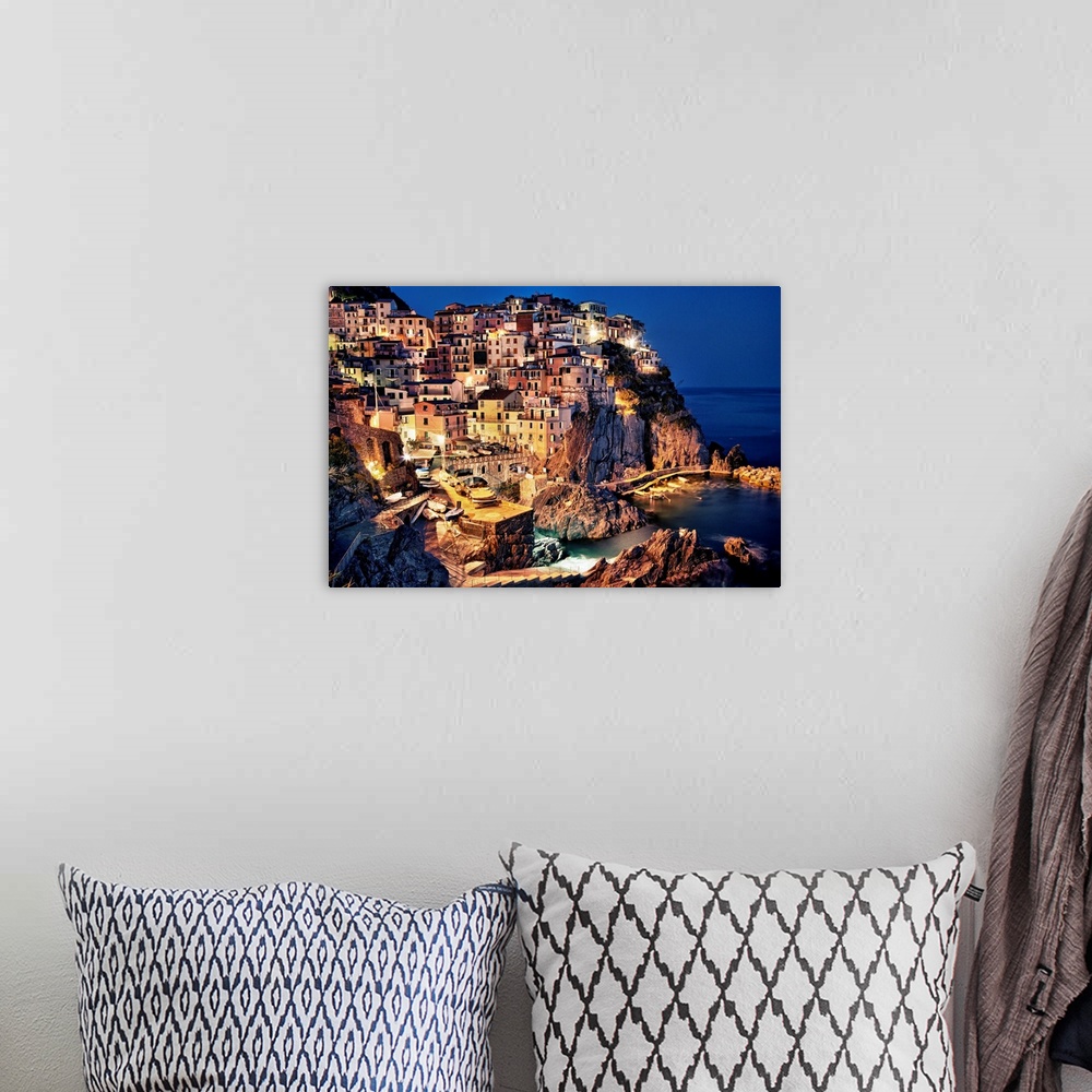 A bohemian room featuring Large photograph taken of homes and buildings sitting within the rocky cliffs of a city in Europe...