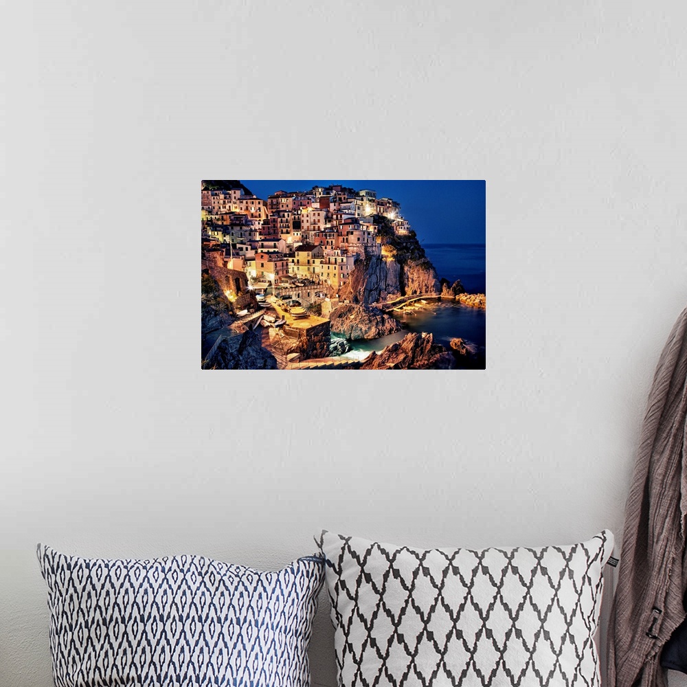 A bohemian room featuring Large photograph taken of homes and buildings sitting within the rocky cliffs of a city in Europe...