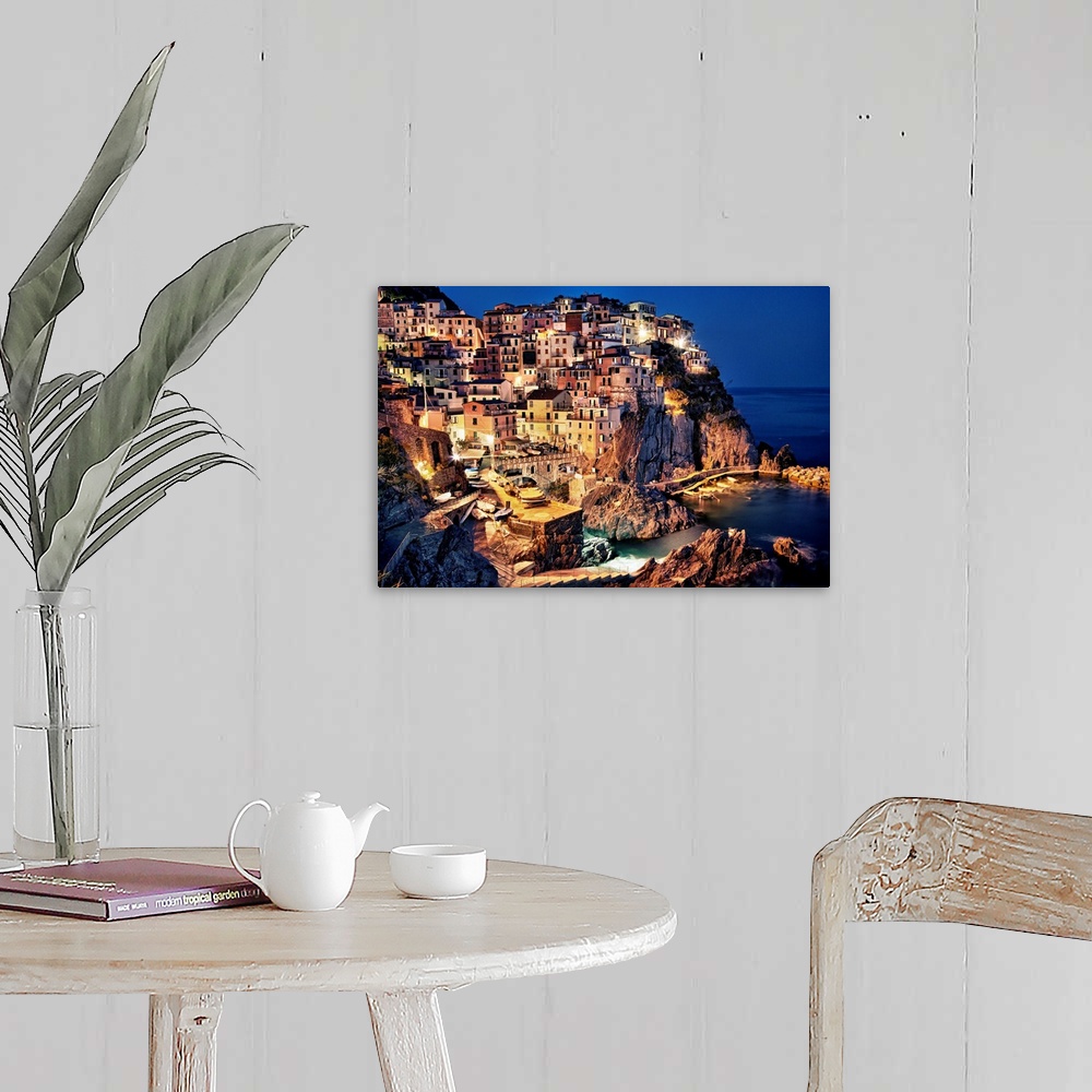 A farmhouse room featuring Large photograph taken of homes and buildings sitting within the rocky cliffs of a city in Europe...