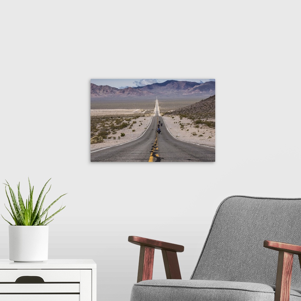 A modern room featuring Motorcycles riding long road into Death Valley National Park
