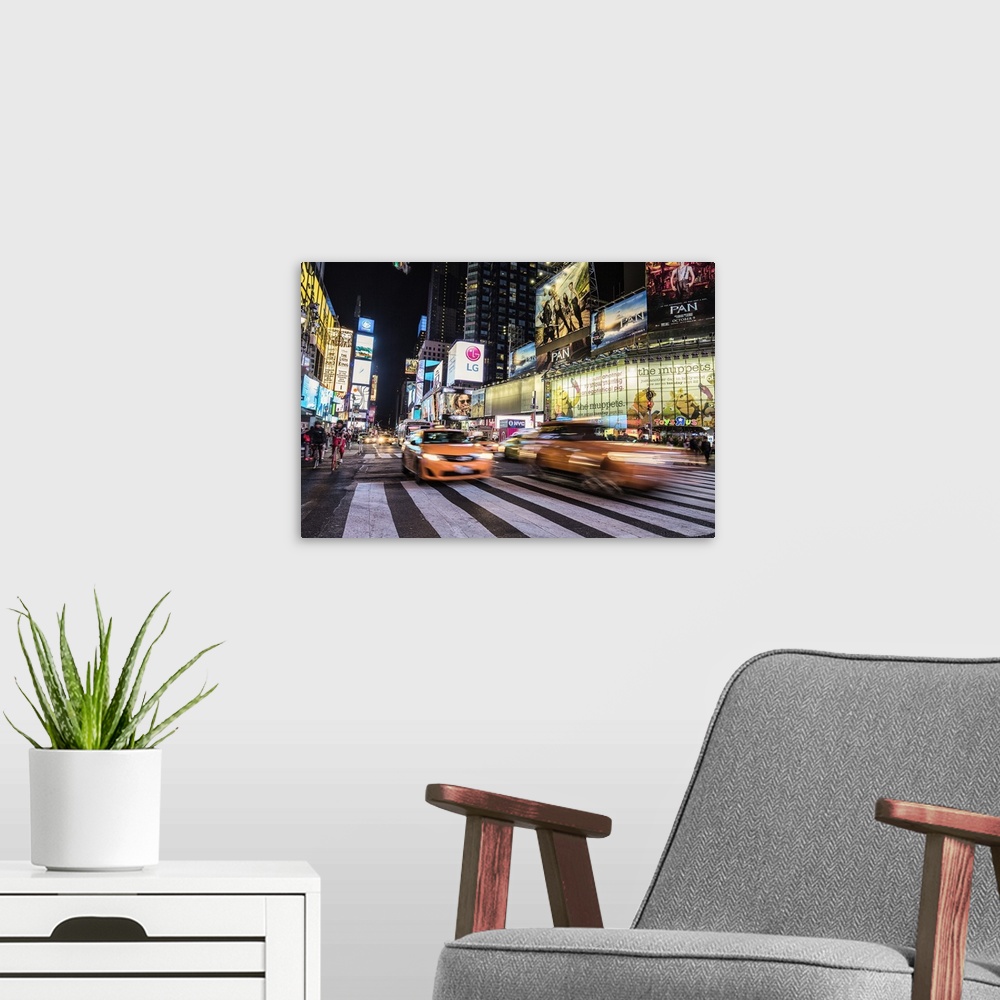 A modern room featuring Neon signs and traffic in Times Square at night, New York.