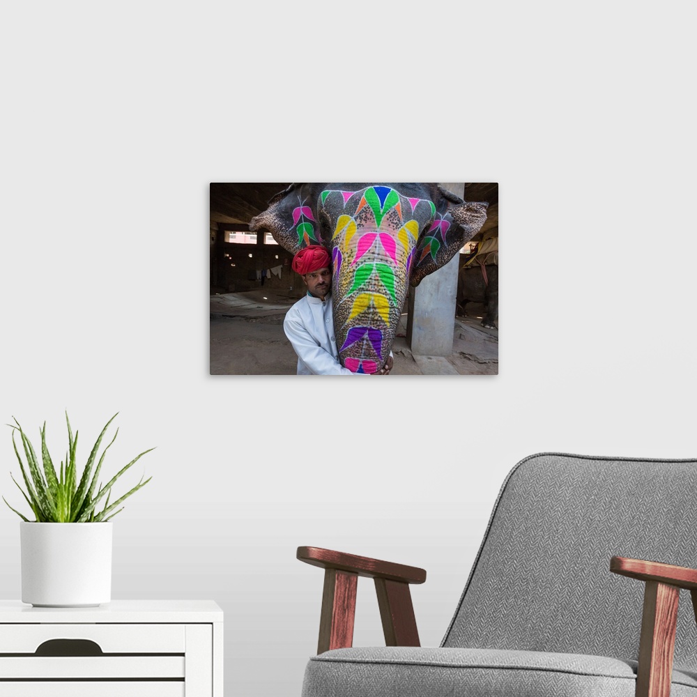 A modern room featuring Painted elephant and its trainer in Jaipur, India.