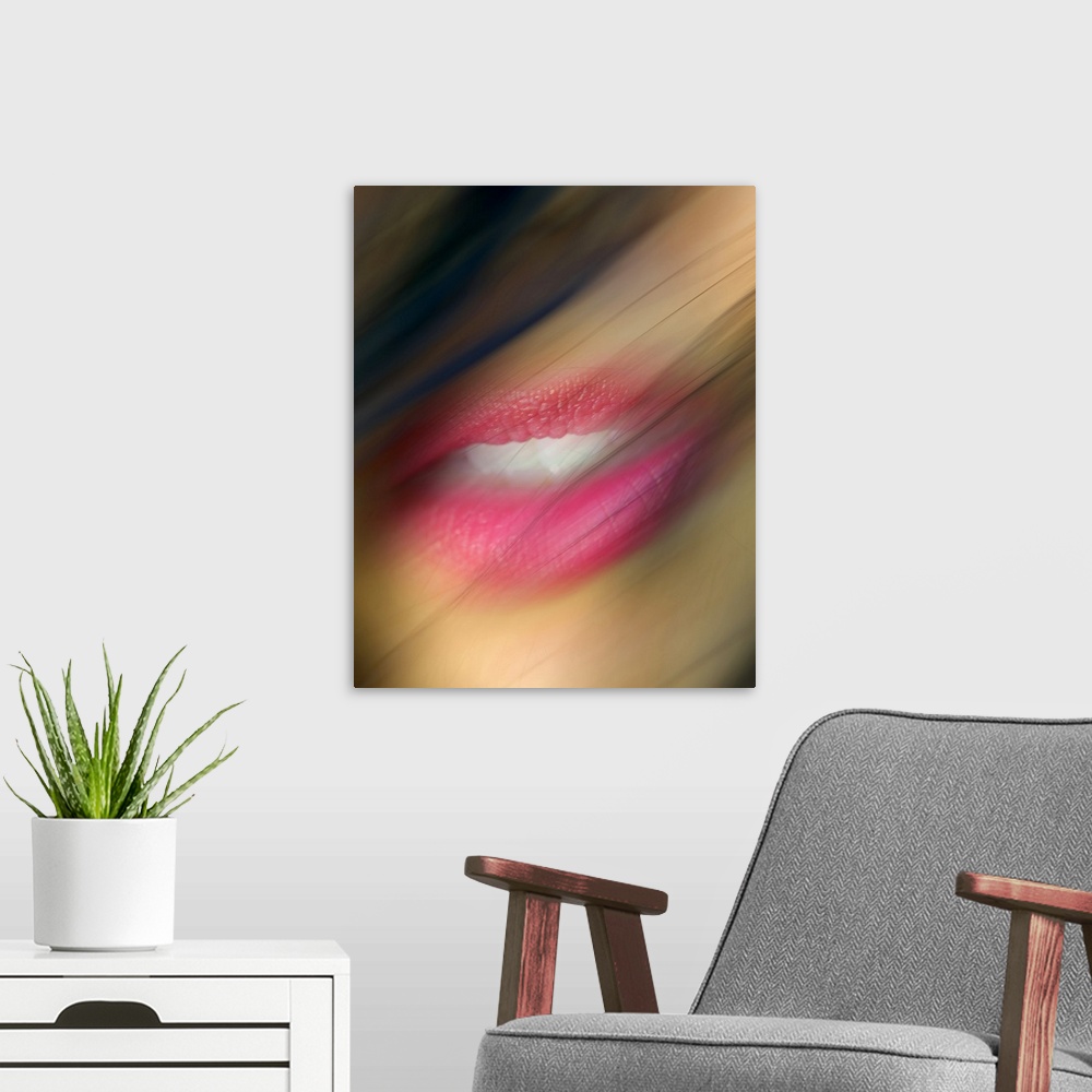 A modern room featuring Hair blows in front of a woman's lips that are photographed closely and appear slight blurry.