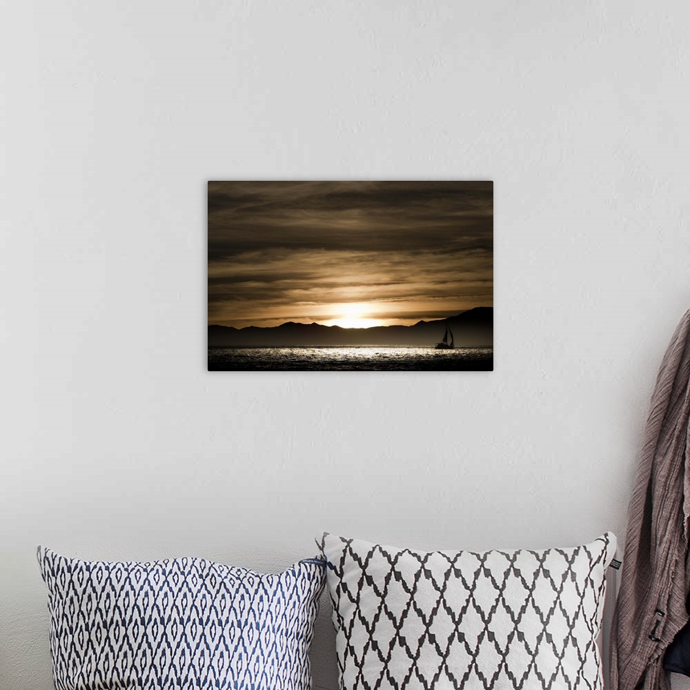 A bohemian room featuring Sailboat in the ocean at sunset