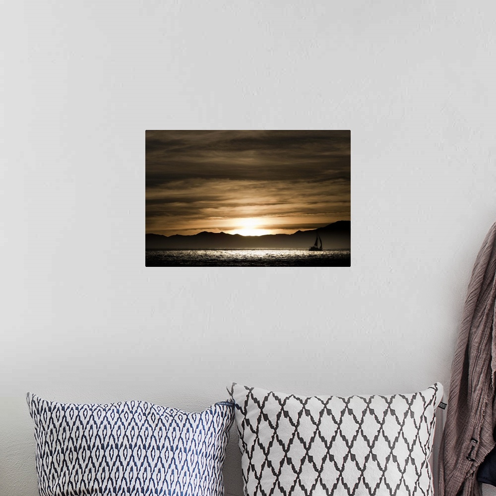 A bohemian room featuring Sailboat in the ocean at sunset