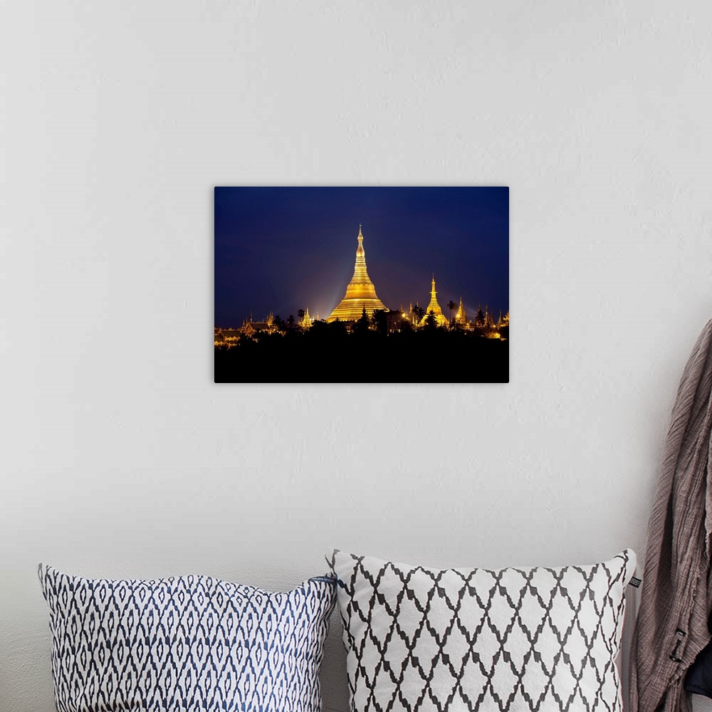 A bohemian room featuring This landscape photograph shows a religious site illuminated in the night riding above the silhou...