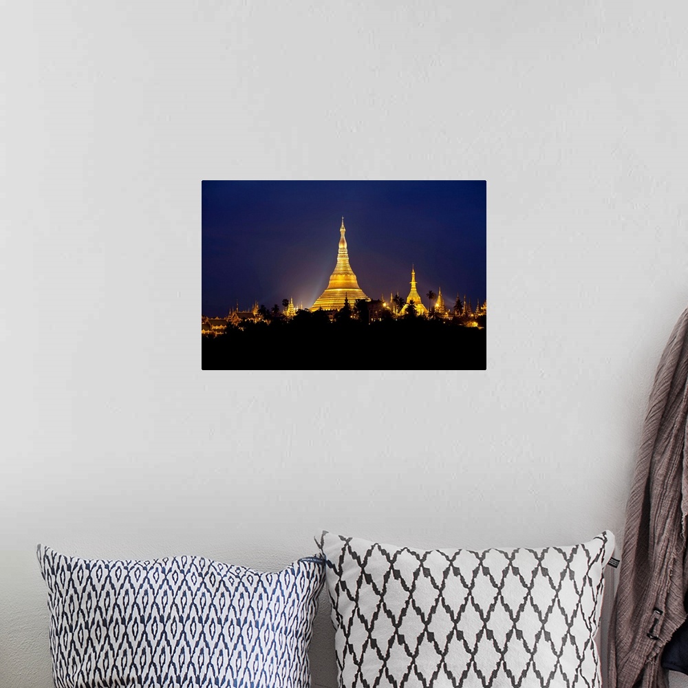 A bohemian room featuring This landscape photograph shows a religious site illuminated in the night riding above the silhou...