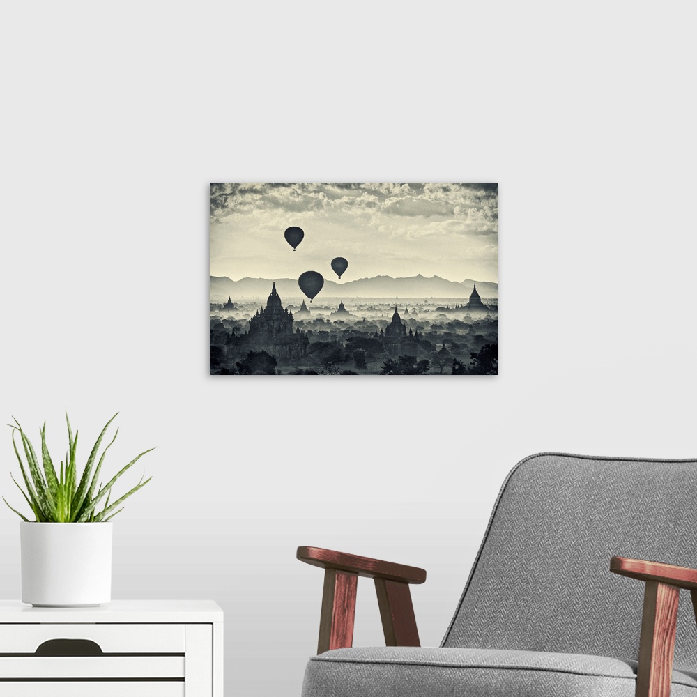 A modern room featuring This monochromatic photograph shows a landscape of hot air balloons rising above the stupas of an...