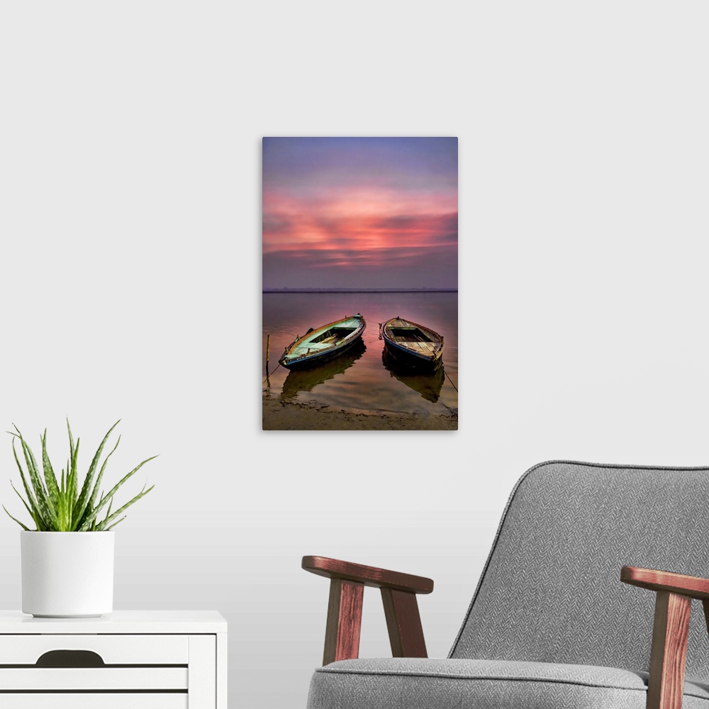 A modern room featuring Picture of two empty wooden boats tied to the sandy shore in the early morning sunrise.
