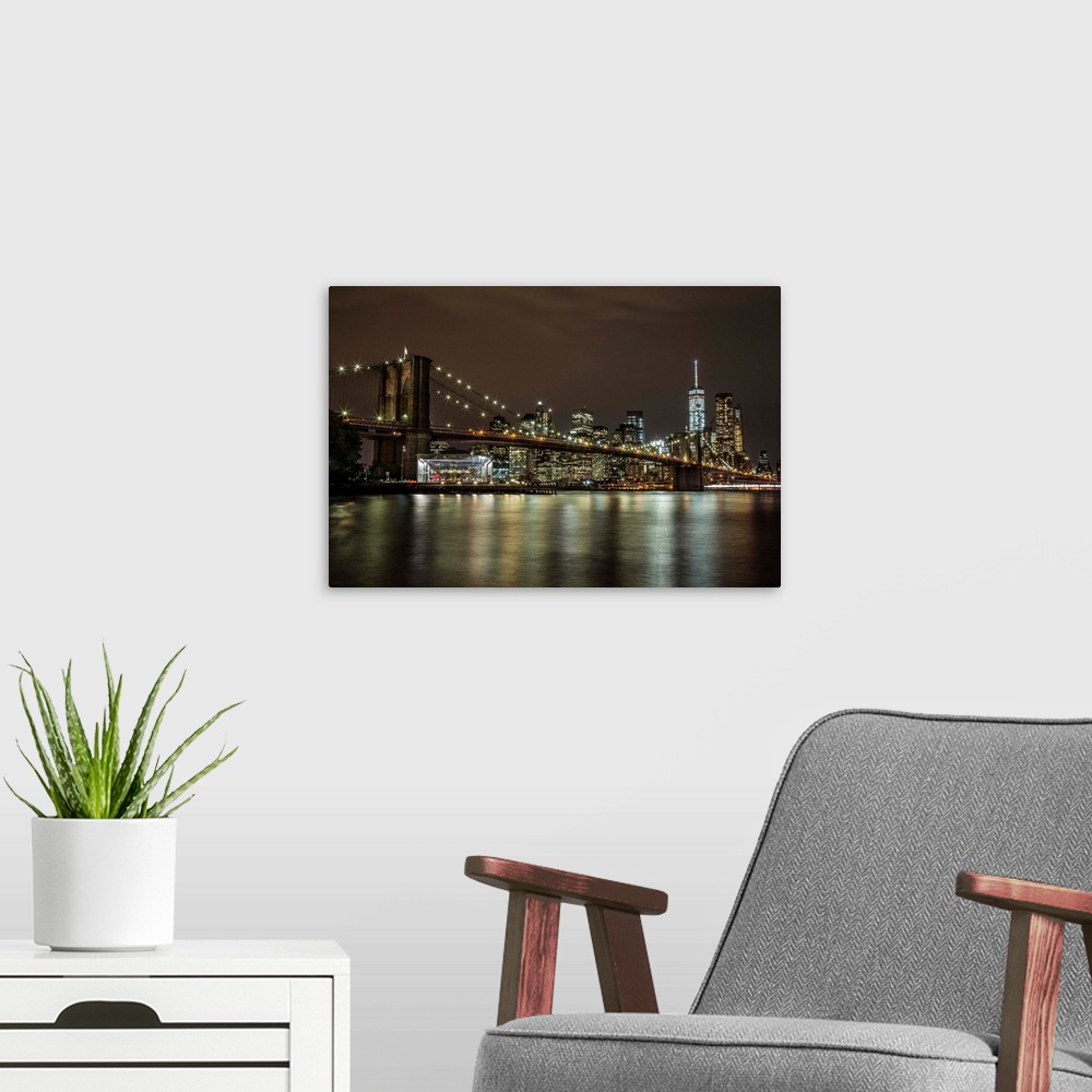 A modern room featuring The Brooklyn Bridge and view of NYC after dark.