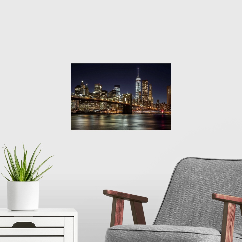 A modern room featuring The Brooklyn Bridge and view of NYC after dark.