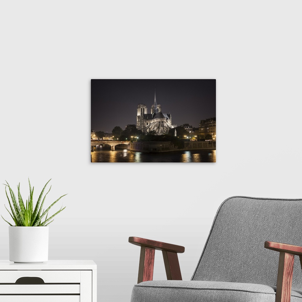 A modern room featuring The Notre Dame Cathedral in Paris at night