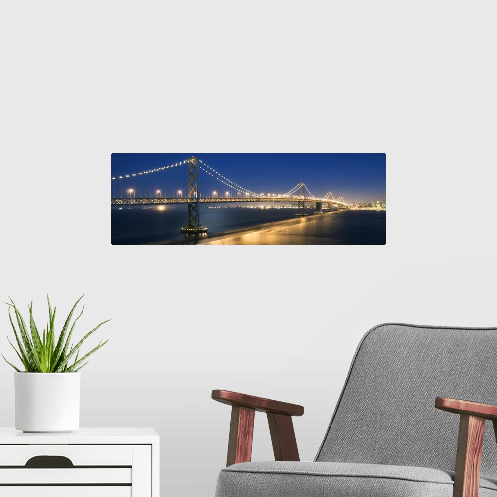 A modern room featuring The Oakland Bay Bridge after dark in San Francisco