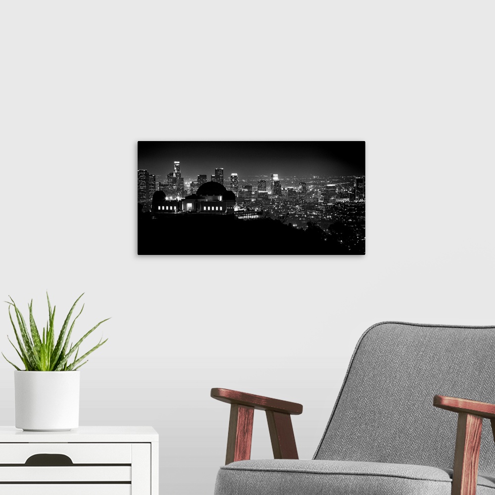 A modern room featuring Large monochromatic photograph displays the busy skyline of a famous California city at nighttime...