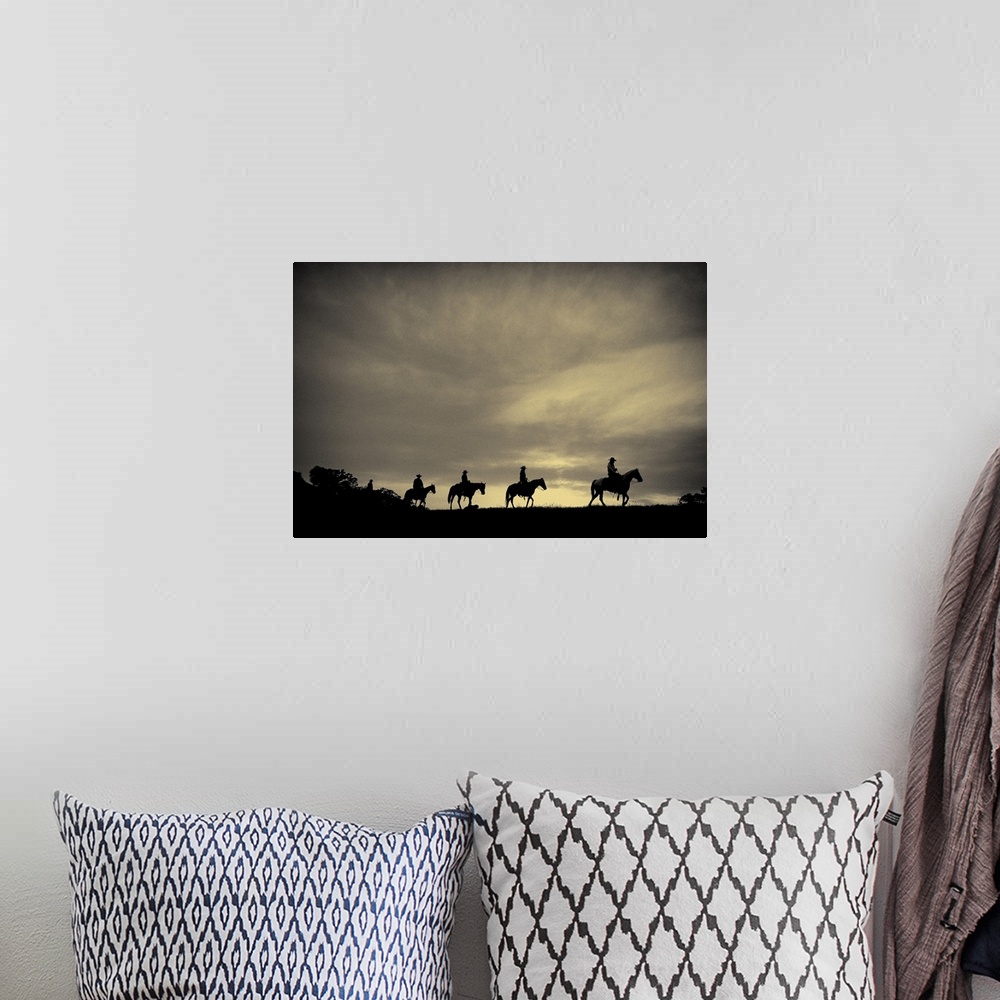 A bohemian room featuring Sepia-toned photo of four cowboys on horseback silhouetted against an overcast sky.
