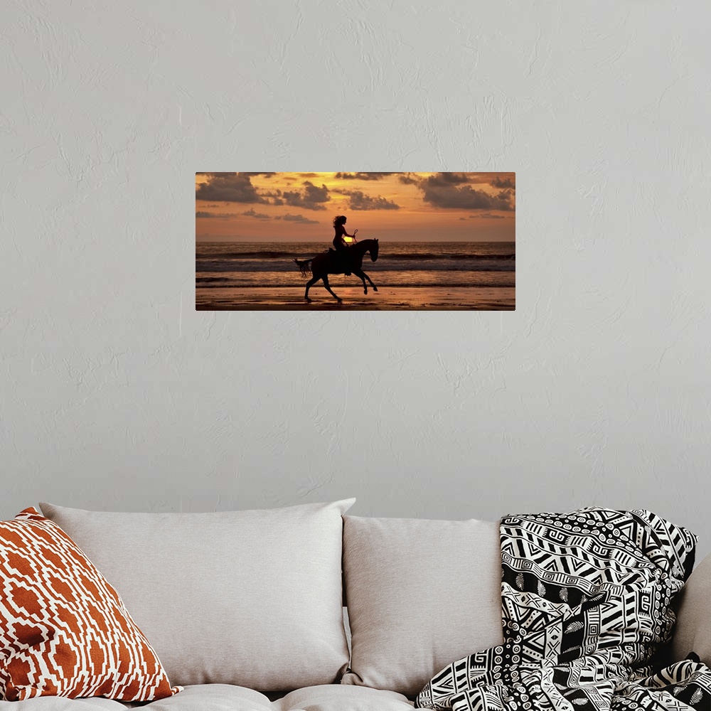 A bohemian room featuring Woman riding a horse on the beach at sunset in Costa Rica