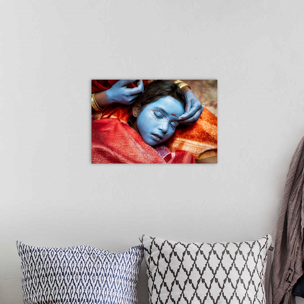 A bohemian room featuring Young girl having her face painted in Varinasi, India