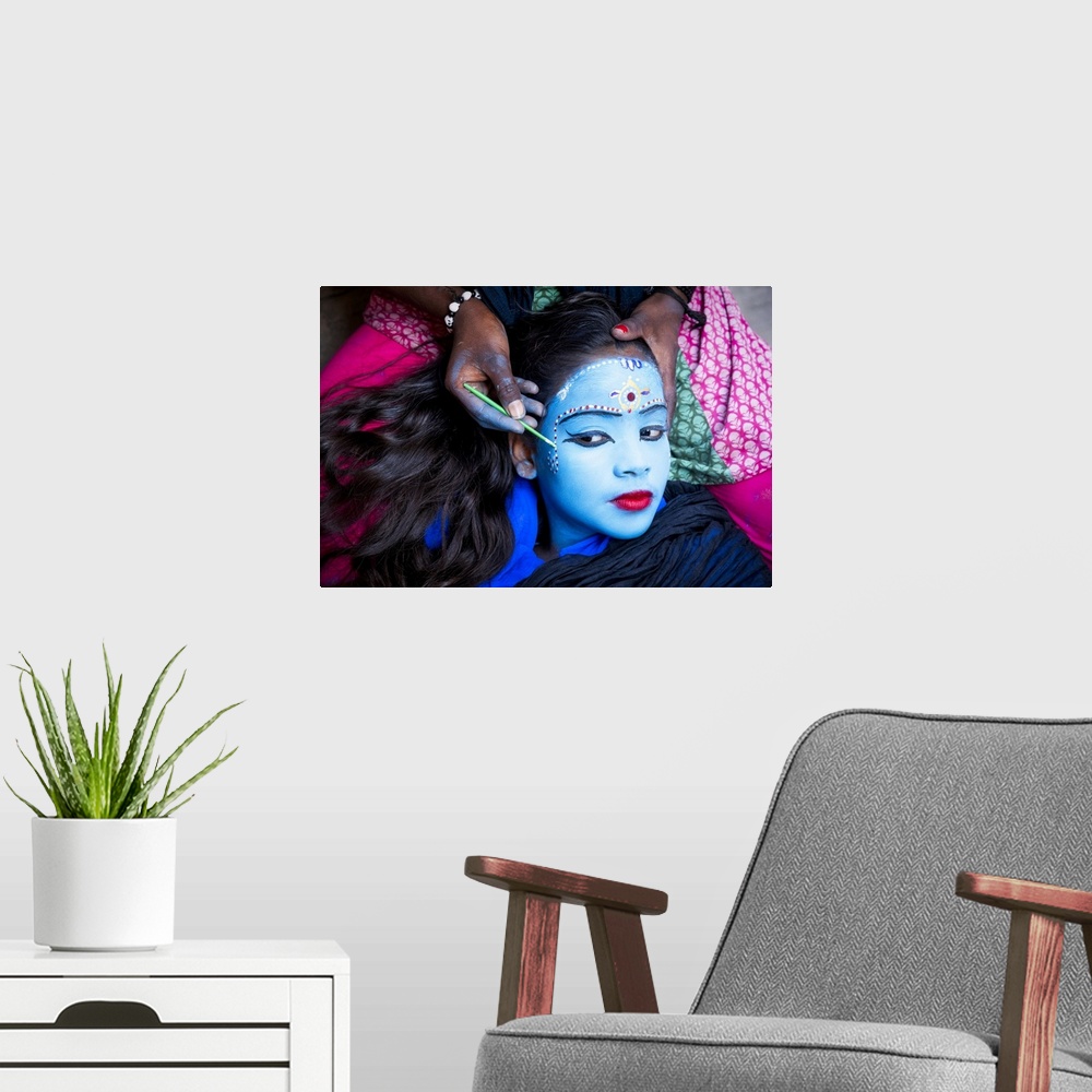 A modern room featuring Young girl having her face painted in Varinasi, India
