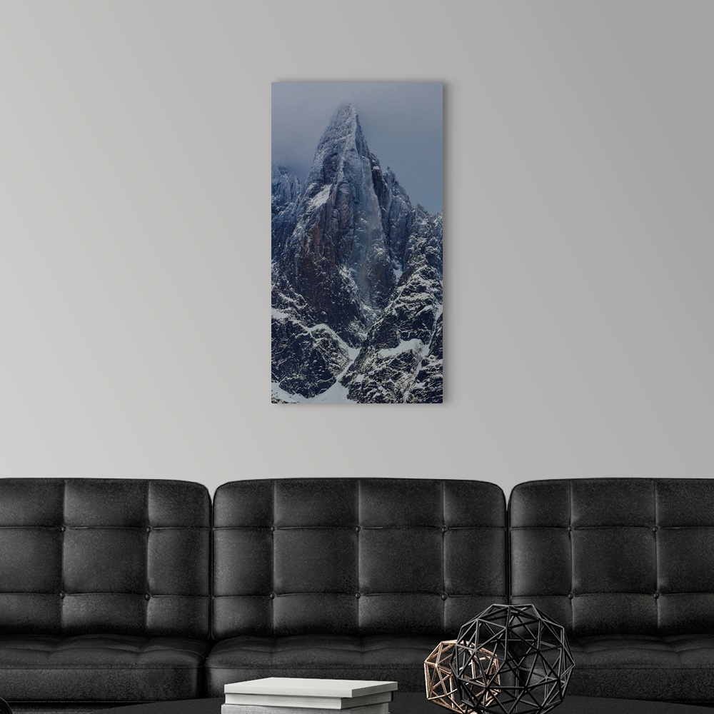 A modern room featuring Landscape photograph of the Aiguille du Dru in the Alps with a grey sky.