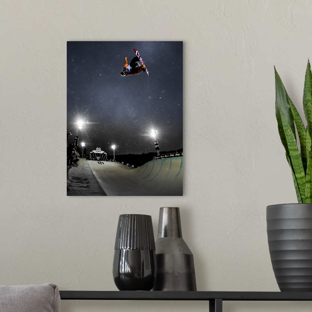 A modern room featuring Snowboarder performing a trick in the air over a course at night, XGames, Aspen, Colorado, 2016.