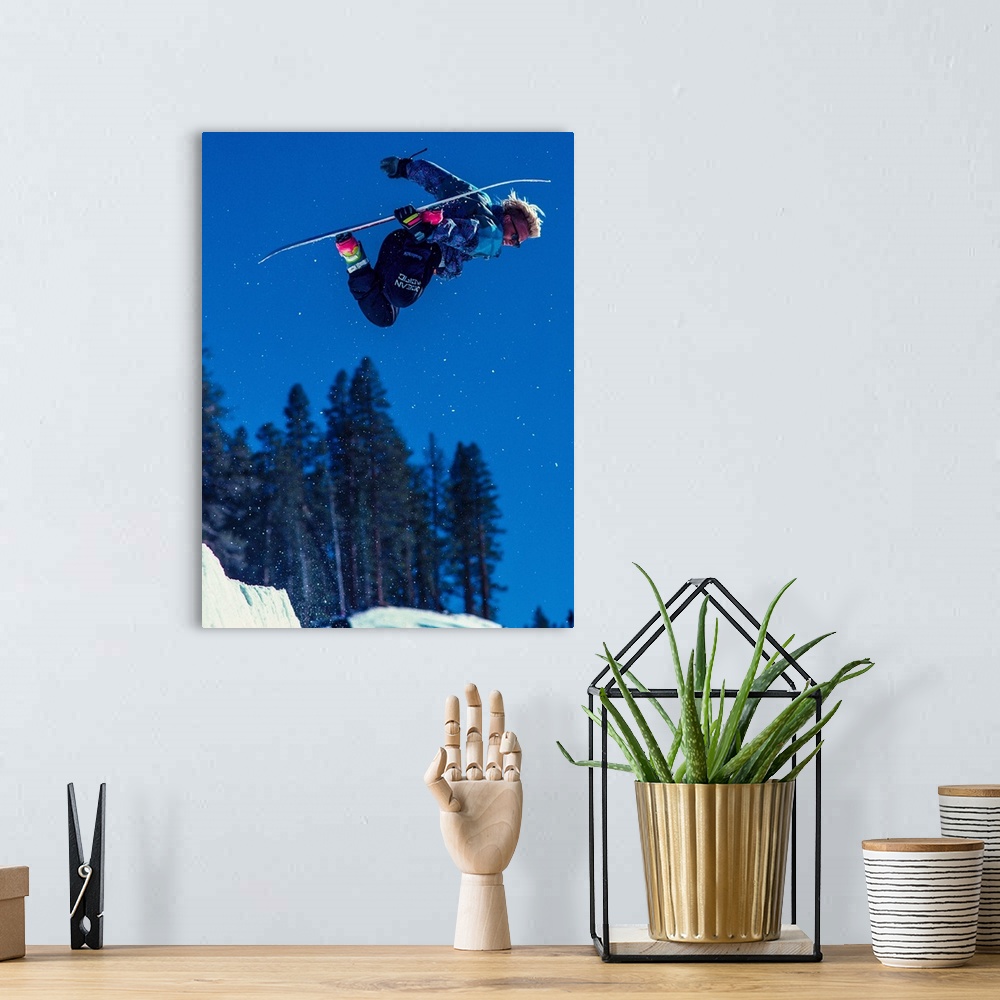 A bohemian room featuring Damian Sanders grabs his snowboard in the air in June Mountain, June Lake, California.