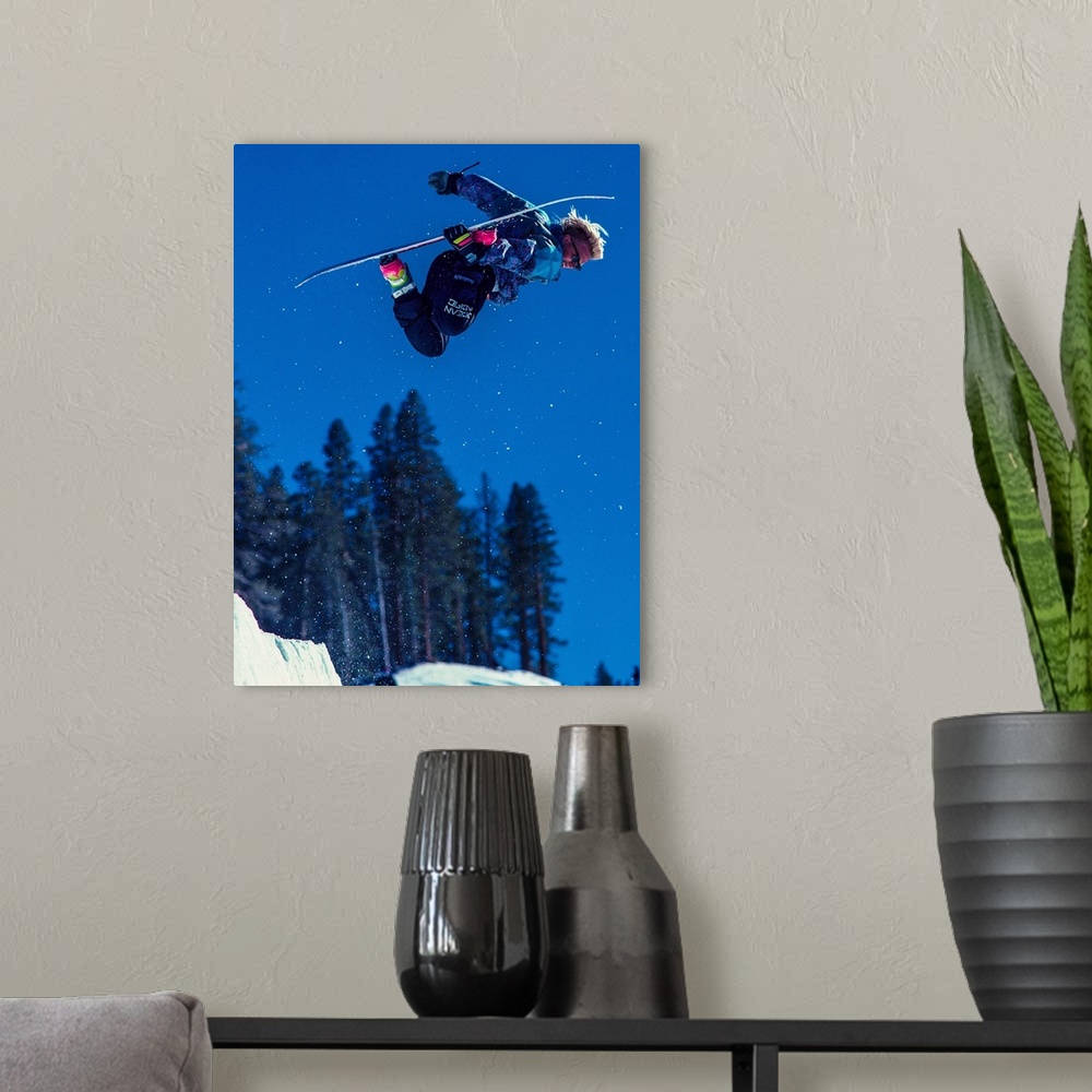 A modern room featuring Damian Sanders grabs his snowboard in the air in June Mountain, June Lake, California.