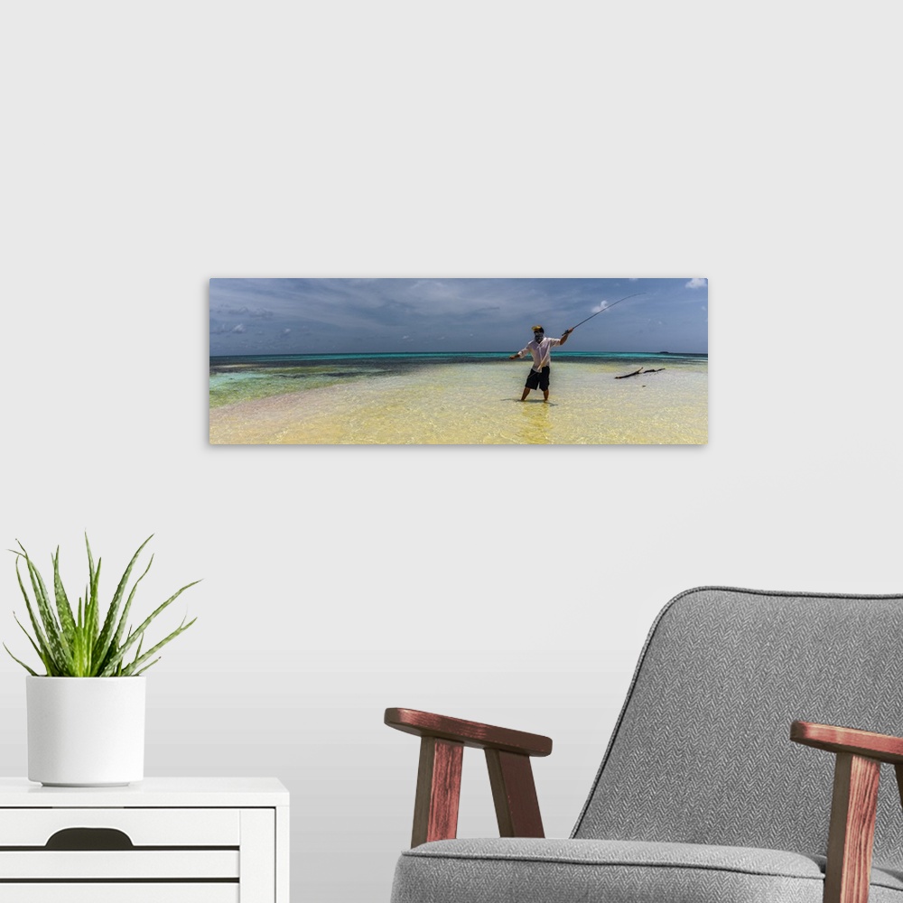 A modern room featuring A man fly fishing in the ocean on a tropical beach in Belize, 2016.