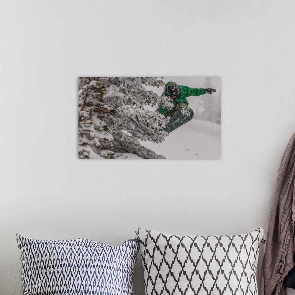 A bohemian room featuring Action shot of a snowboarder in green doing a grab mid-air.